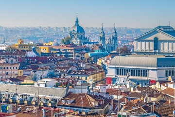 Panoramic view of Madrid with the iconic Royal Palace and Almudena Cathedral in the distance, Spain. The photo captures the beautiful cityscape with historic rooftops and landmarks in the clear sky