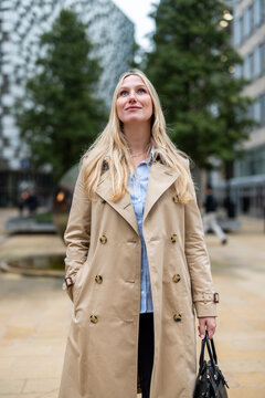 Businesswoman with hands in pocket standing on street in city