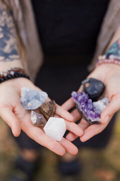 Hands of woman holding various natural stones