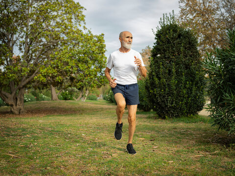 Senior man running in park on sunny day