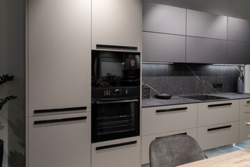 Black electrical built-in oven and microwave in a modern kitchen