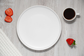 Empty white plate over white wooden background