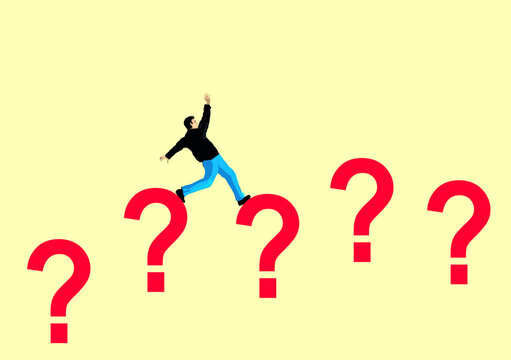 Man balancing on question mark against beige background