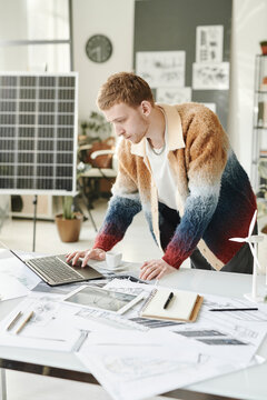 Employee working on blueprints in modern office