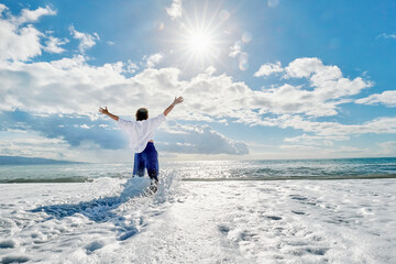 Mature woman standing in water at beach on sunny day