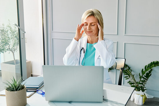 Doctor working on laptop in private medical office