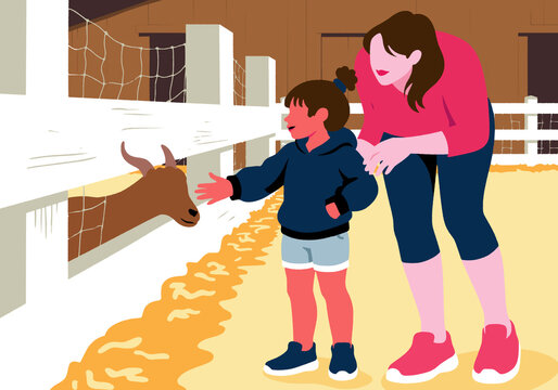 Mother with daughter petting goat in zoo