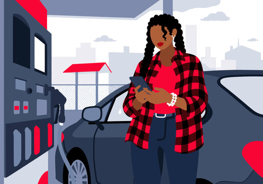 Woman pumping gas and using smart phone standing at station