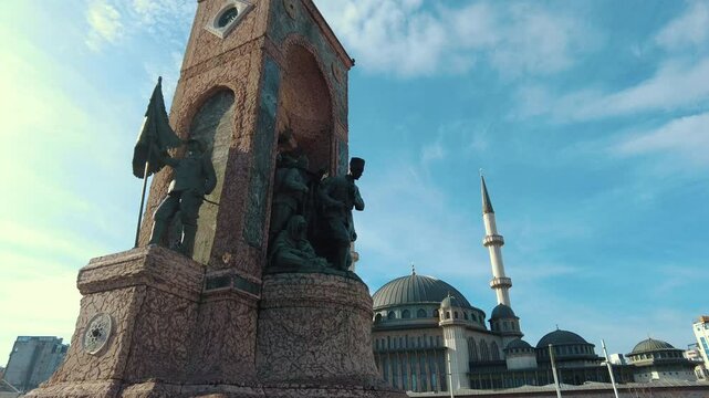 Republic Monument and Taksim Mosque can be seen in Taksim Square in Istanbul. The camera moves from the monument towards the mosque.
