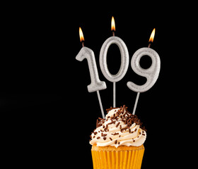 Number 109 shaped candles - Birthday cupcake on black background.