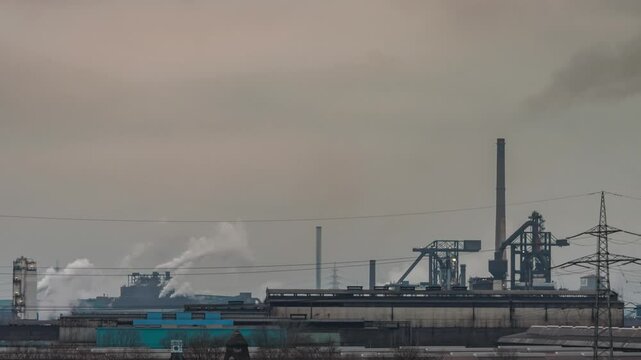 Heavy Industry, Duisburg Germany, smoke and emissions released from factories on gloomy day, time lapse