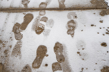 Footprint in slushy melting road. Melting snow road
