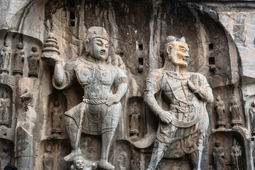 Luoyang Longmen, China: Ancient Buddhist statues in the Longmen grottes Fengxian main cave that dates back from the 7th century in Central China.