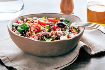 Quinoa salad, healthy Mediterranean lunch with fresh organic vegetables, cheese, and olives