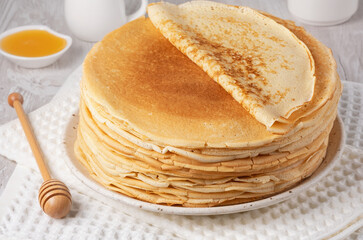 Stack of traditional russian pancakes blini on a white table. Homemade russian thin pancakes blini. Russian food, russian kitchen