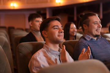 Group of people watching theatrical performance in theatre