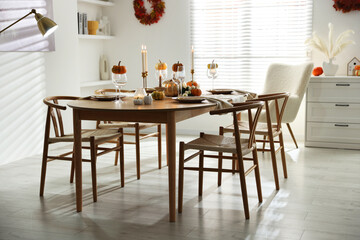 Stylish dining room with beautiful table setting and autumn decor