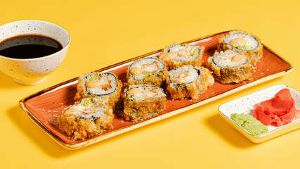Sushi rolls on tray on yellow background