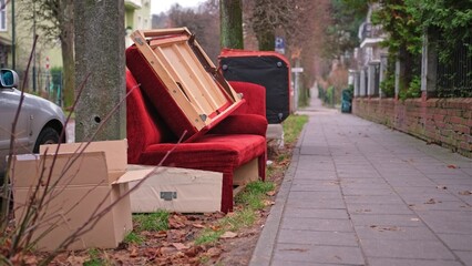 Fototapeta premium Old Unwanted Furniture Couch Dumped on Sidewalk on Bulk Garbage Collection Day for Curbside Pickup by City Cleaning Services