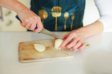 Woman cutting onions in the kitchen to prepare homemade cutlets