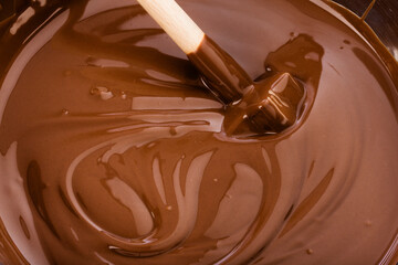 stirring liquid chocolate with a wooden beater