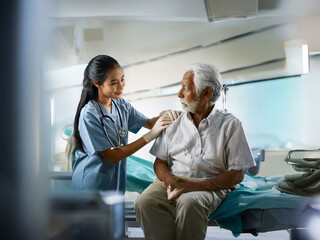 Fototapeta premium A young nurse provides compassionate care to a senior patient in a hospital room. The scene emphasizes empathy and healthcare.