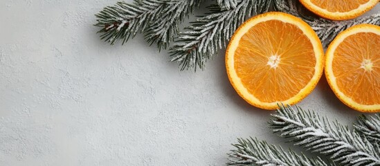 New Year celebration concept featuring orange slices arranged as digits with fir tree branches on a light grey background adding festive spirit