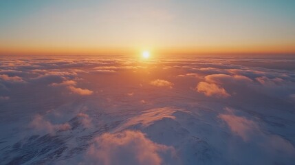 Aerial view of serene snowy mountains at sunset with vibrant clouds creating a stunning natural landscape scene in the sky