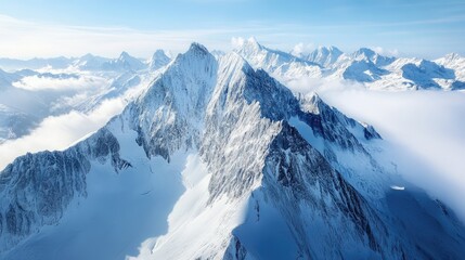 Majestic Alpine Mountain Range Surrounded by Clouds and Snow in a Clear Blue Sky