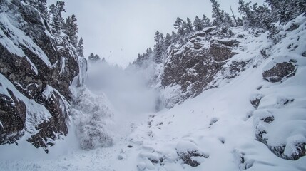 Obraz premium Snow avalanche cascading down rocky mountains in winter landscape snow falling amidst rocky terrain and trees in a serene natural setting