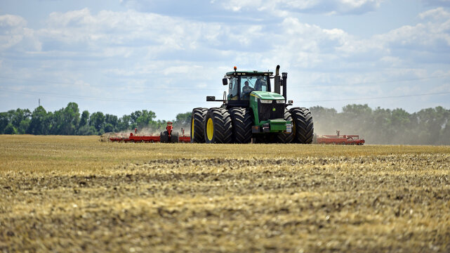 Kyiv, Ukraine, 19.07.2023. tractor in a field, tractor with a plow on an agricultural field. big green tractor working in the field, soil preparation, harvesting, business, agriculture. Editorial