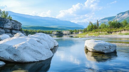 Fototapeta premium Serene landscape of a tranquil river bank featuring large white boulders and majestic mountains under a clear blue sky.