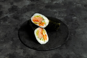 Sushi burrito sliced on black plate