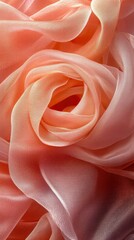 Obraz premium A close-up of soft, flowing fabric in shades of peach and pink, resembling a flower.