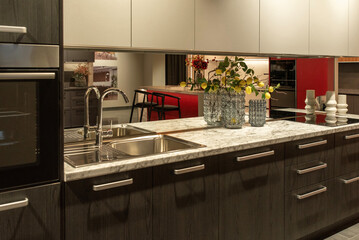 Chrome faucet with mirrored backsplash and sink in a kitchen