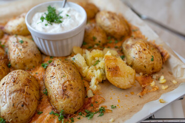 Parmesan baked jacked potatoes on a baking tray with a dip. Delicious party food