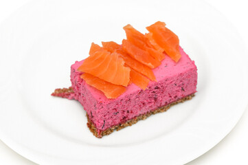 Delightful salmon cheesecake with a vibrant pink hue served on a white plate