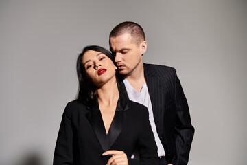 A fashionable couple poses intimately in a studio, radiating romance and style for Valentines Day.