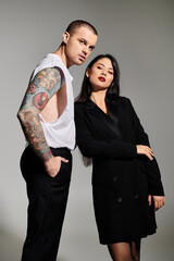 A stylish young couple poses in a studio, radiating romance and fashion.