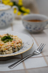 Porcja sałatki jarzynowej. Kolorowe warzywa w delikatnym sosie majonezowym prezentowane na eleganckim talerzu. Doskonałe zdjęcie do artykułów o polskich potrawach lub rodzinnych spotkaniach.