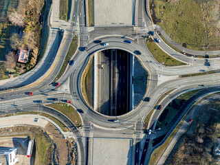 Krakow, Poland. Wegrzce interchange on new S52 highway (below) opened on December 23, 2024. Part of freeway around Cracow. Traffic circle with a hole inside and ramps. Aerial view from above at sunset
