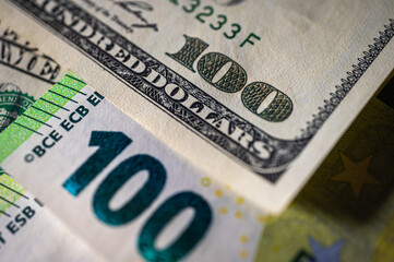 Obraz premium 100 dollar bills and 100 euro bills close-up symbolize wealth, international finance, currency exchange and world economy, world currency market, competitors