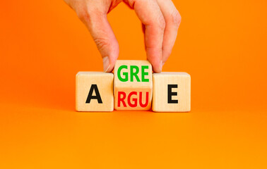 Agree or argue symbol. Concept words Agree or Argue on wooden block. Beautiful orange table orange background. Businessman hand. Business agree or argue concept. Copy space.
