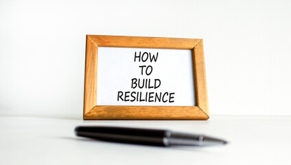 How to build resilience symbol. Concept words How to build resilience on beautiful wooden picture frame. Beautiful white table white background. Business how to build resilience concept. Copy space.