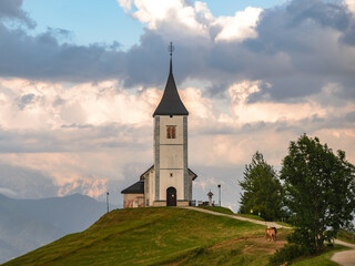Idyllic scenery in Slovenia with an old church on a hill in Jamnik