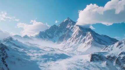 Obraz premium Majestic Snow-Capped Mountain Under Bright Blue Sky and Clouds