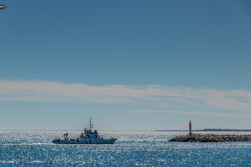 Fototapeta premium A White Boat Sailing on the Blue Beach of Mahdia, Tunisia. North Africa