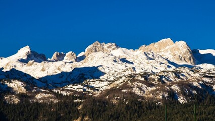 Snowy mountain peaks beneath a clear blue sky.
