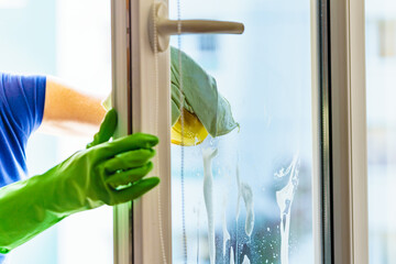 Woman cleaning window at home