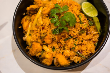 Tom Yum fried rice with seafood in black bowl. Thai food